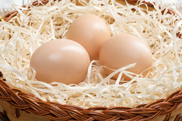 Easter chicken eggs in a nest on a wooden background