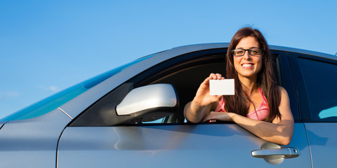 Woman in car showing driving license