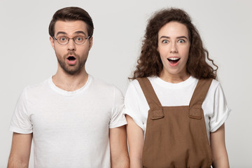 Positively shocked guy and happy girl standing with opened mouths.