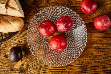 Fototapeta na wymiar Red plums in a glass fruit plate