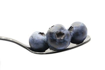 blueberries on metal spoon. White background
