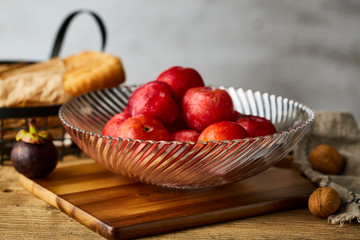 Red plums in a glass fruit plate