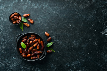 Dates. Delicious sweet turkish dates on black stone background. Top view. Free space for your text.