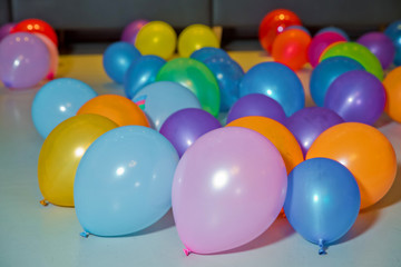 Obraz premium Flat lay of colorful balloons . holiday, children's party, a games room, a box filled with small colored balls . Different color balloons on the floor .