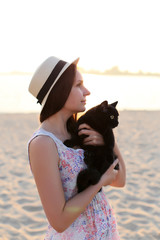 vertical portrait of a young brunette with a cat in her arms