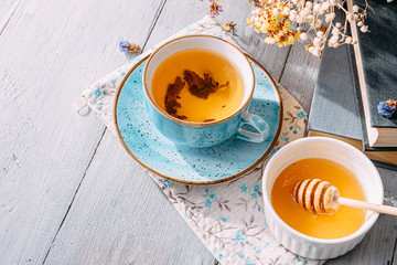 tea and a book in the spring sunshine. near honey and flowers
