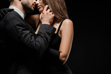 cropped view of man touching face of woman in dress isolated on black