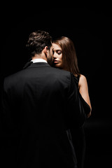 attractive woman standing with boyfriend isolated on black
