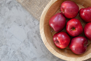 Closeup Red apples. Ripe red apples in wooden box. Top view with space for your text. Apples In Wooden plate on gray concrete table. Organic food and healthy food concept. raw food diet,  vegan, Diet