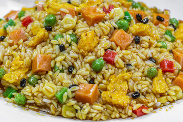 Food flat lay of traditional Chinese Fried Rice with vegetable and spices is on a big white plate