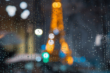 Blurred Eiffel Tower Silhouette Behind a Rain Dropped Window During Night