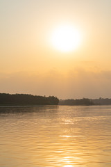 Amazon rainforest sunset during a boat trip with a reflection of the trees in the water. Puerto...