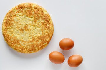 Delicious Spanish omelette with a few eggs on a white background with cpopy space