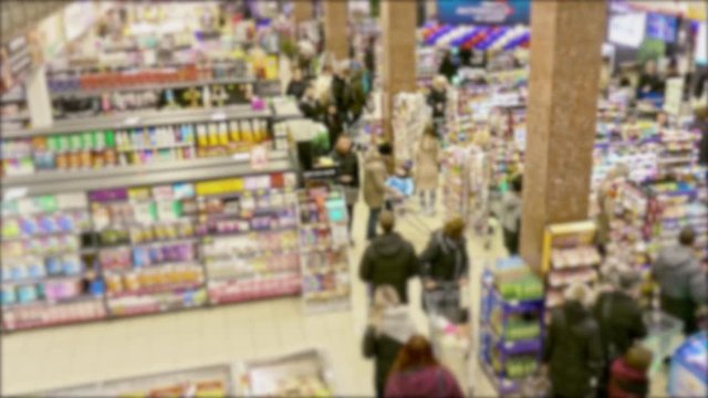 Cashier at supermarket / Retail checkout / Paying groceries. Unrecognizable buyers with carts move in queues to pay for purchases at the supermarket cashier. Fast motion.