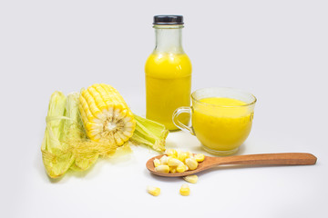 Delicious homemade fresh corn milk in glass bottle with corn seeds on white background.