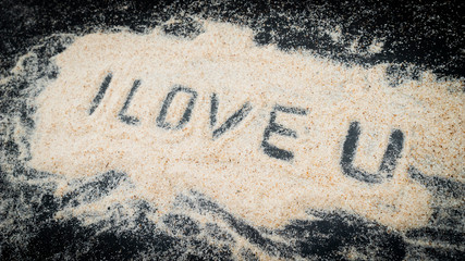 Fototapeta premium Top view of I LOVE U text written on white sand
