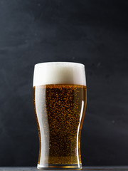 Glass of light beer lager on a dark background
