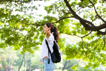 Happy freedom woman enjoy nature at green park. Freedome concept. Backpack travel summer