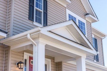 Portico leading to the entrance of vinyl horizontal lap siding covered building, with a roof...