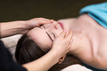 Obraz na płótnie Canvas Young beautiful woman and face massage in spa