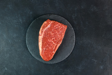 Raw fresh marbled meat on dark background top view