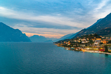 Lake Garda Italy in cold foggy day in winter holidays with city historical view, lake and mountain and cable car 