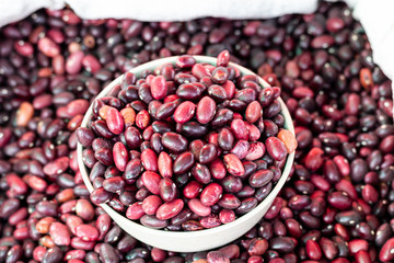 Grains red bean in a bowl on a pile of red beans.