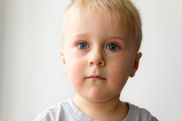 Portrait of a little blond boy with blue eyes