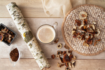 Fragrant natural custard coffee with dried mushrooms cep and chaga on a wooden background. Brunch of birch, dried ceps and powder top view image