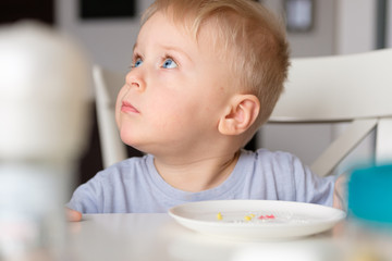 Little boy is eating a boiled egg. Easter breakfast