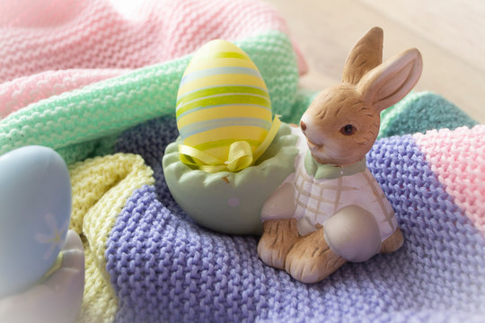 Little decoratif rabbit with easter egg on pastel colorful knitted pleid