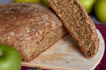 Hot homemade bread cut into 2 pieces on wooden board