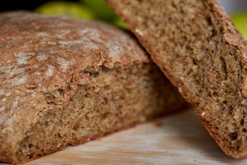 Hot homemade bread cut into 2 pieces on wooden board