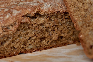 Hot homemade bread cut into 2 pieces on wooden board