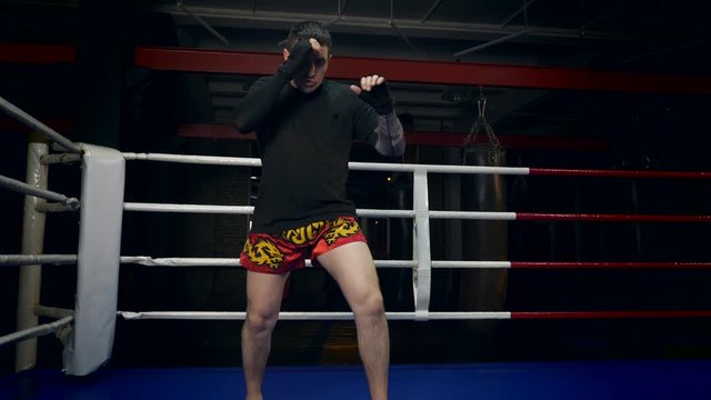 Slow motion Muay Thai Fighter Blows Fast Forceful Thrusts with the Foot. Training Kicks In Boxing Ring At Gym