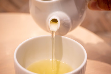 熱い緑茶を湯呑に注ぐところ