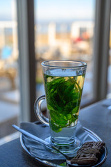Tea glass with hot mint tea made fron fresh green leaves of  mint plant