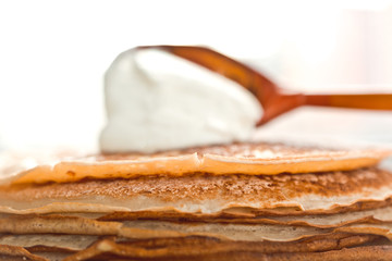 pancakes with sour cream are stacked on top of each other