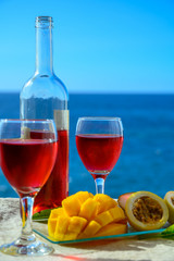Two glasses with rose wine served outdoor with exotic fruits on tropical island La Palma, Canary islands, Spain with beautiful blue ocean view