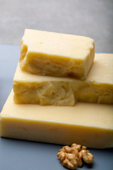 Cheese collection, matured and orange original British cheddar cheese in blocks served on grey plate