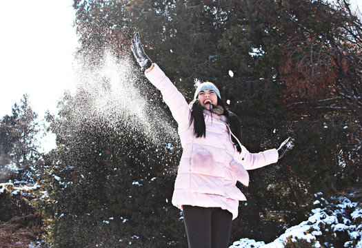 a girl playing snowballs in winter in parck
