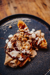 Shrove Tuesday, Pancake Day. Delicious pancakes served with fresh bananas, chocolate sauce and nuts. Concept of English traditions and food..