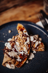 Shrove Tuesday, Pancake Day. Delicious pancakes served with fresh bananas, chocolate sauce and nuts. Concept of English traditions and food..