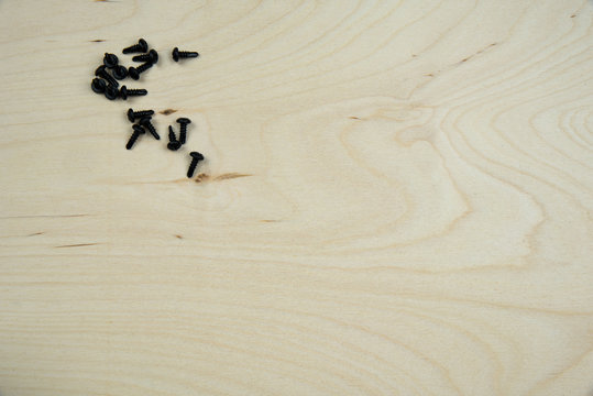  screws on wooden panel closeup