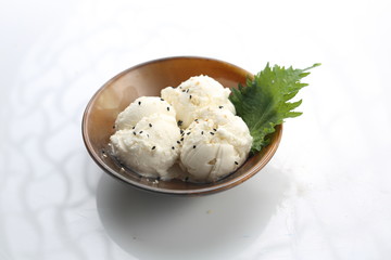 Scoops of coconut ice cream in a bowl. Dessert isolated on white.