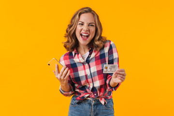 Image of young beautiful woman holding cellphone and credit card