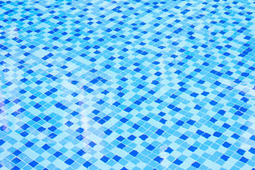 Ripple Water in swimming pool with blue tile floor background