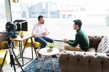 Journalist Interviewing Businessman In Workplace