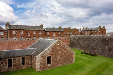Fototapeta na wymiar Red brick barracks in historical Fort George, Scotland with a ditch