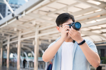 Asian tourists are standing, taking pictures with a tourist camera in the city.